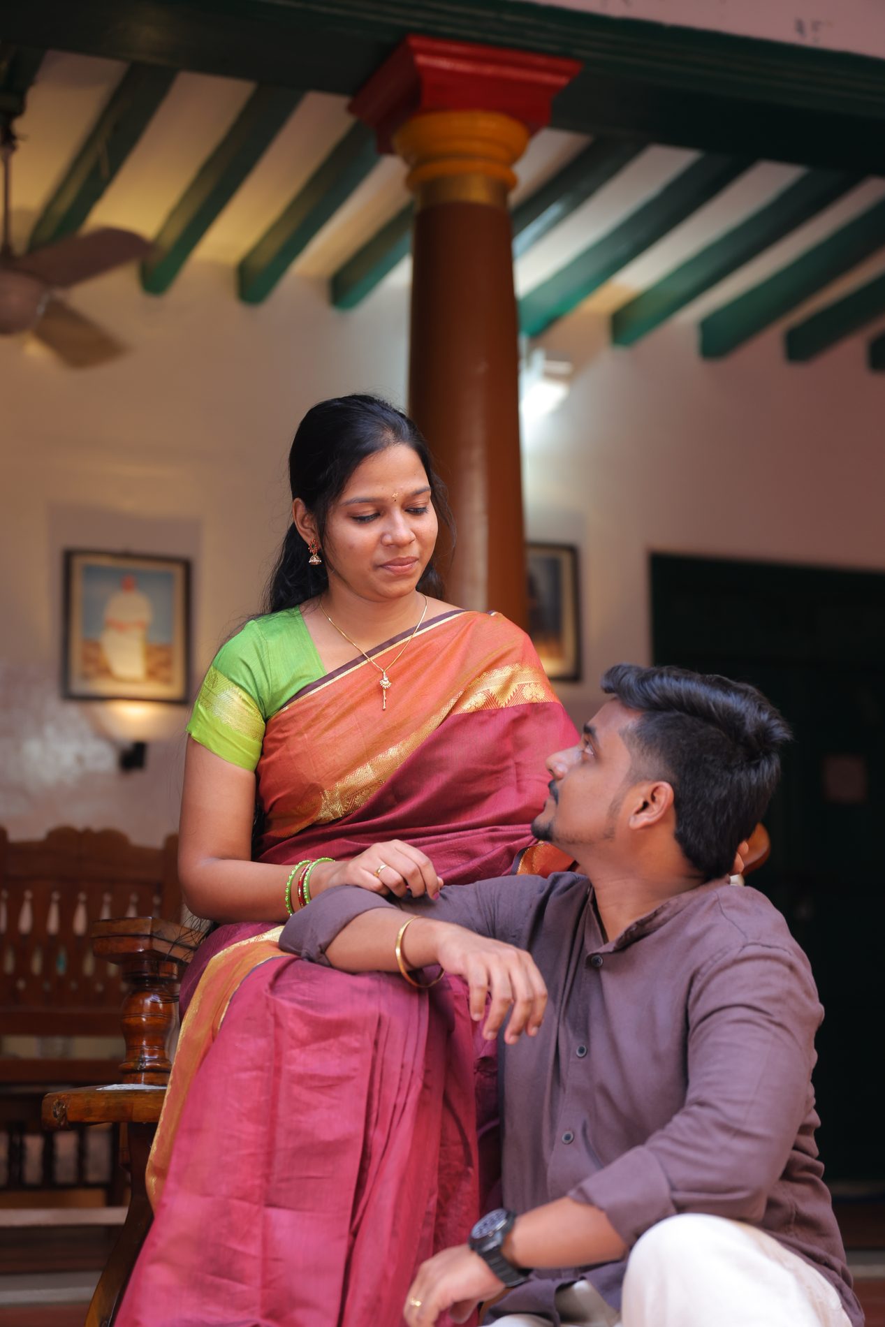 Venkatesh and Brindha sharing a close conversation in a heritage courtyard