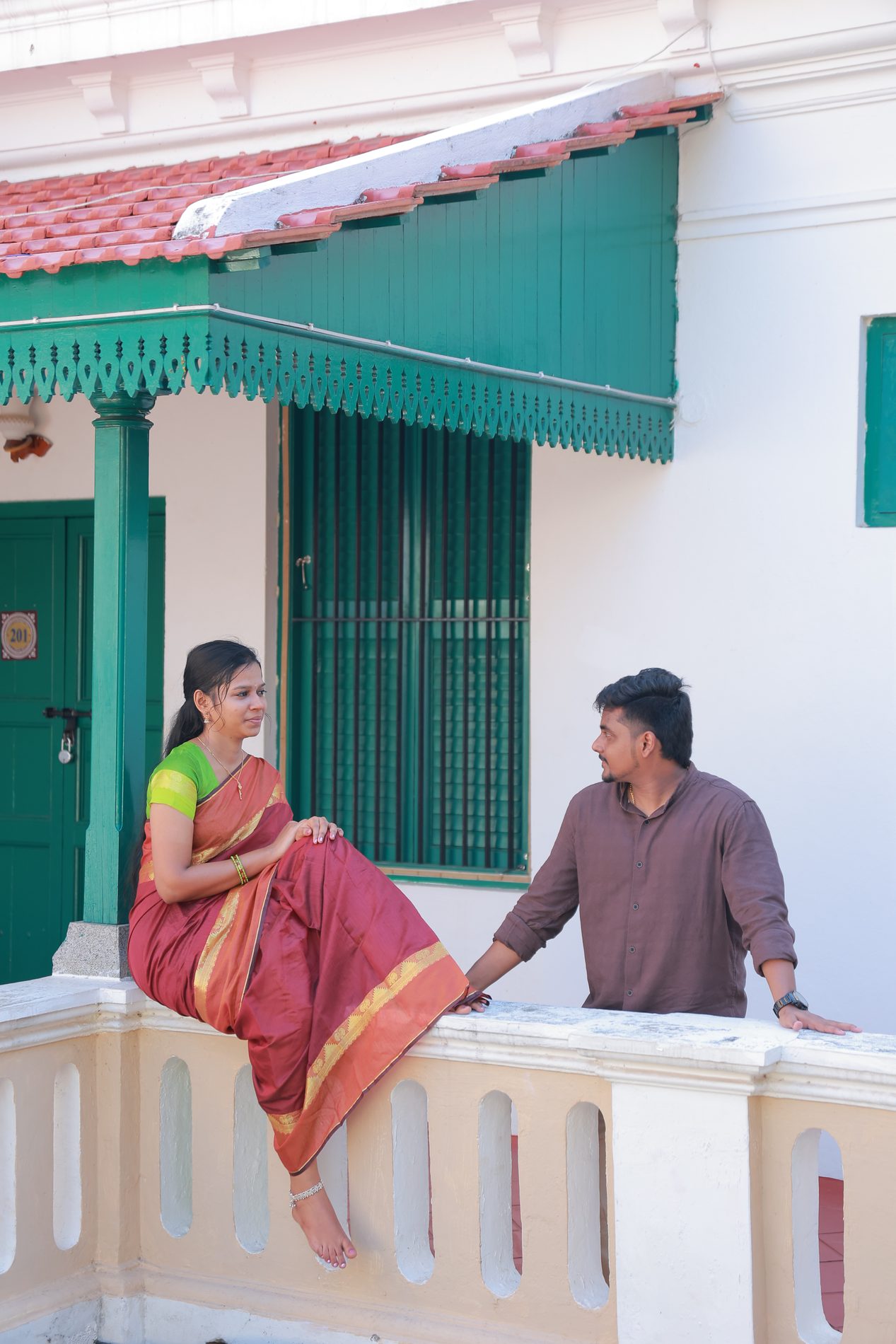 Brindha and Venkatesh on a traditional wooden swing