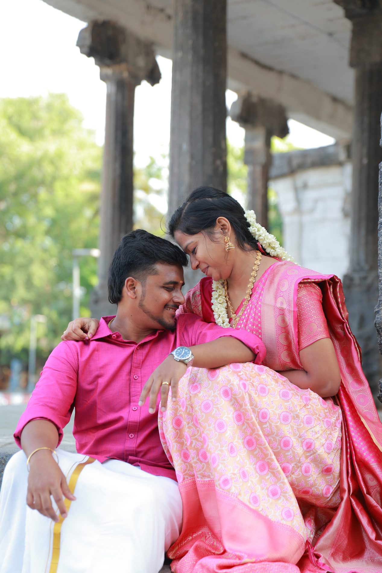 Venkatesh and Brindha in a tender forehead-to-forehead moment among temple pillars
